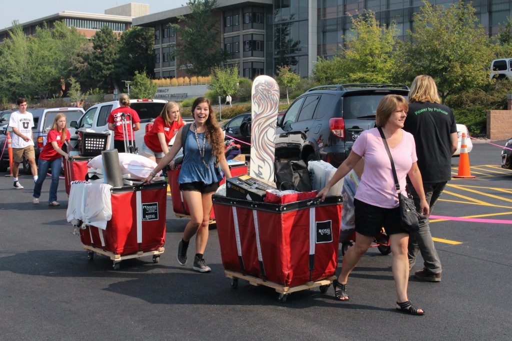 Students, parents and UCrew volunteers with red carts on move-in day